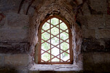a window in a castle with stone walls and bars