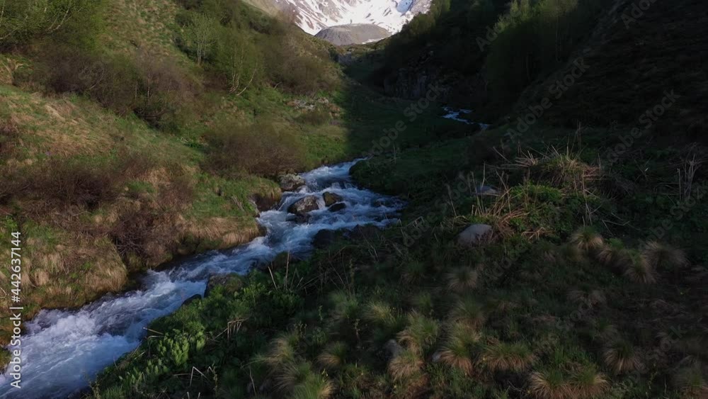 Cinematic drone shot following a mountain stream then tilting up to reveal the Georgian Dolomites in the Caucasus mountains Cinematic drone shot following a mountain stream then tilting up to reveal the Georgian Dolomites in the Caucasus mountains