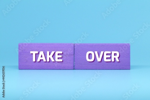 purple cubes with the word take over. Business concept