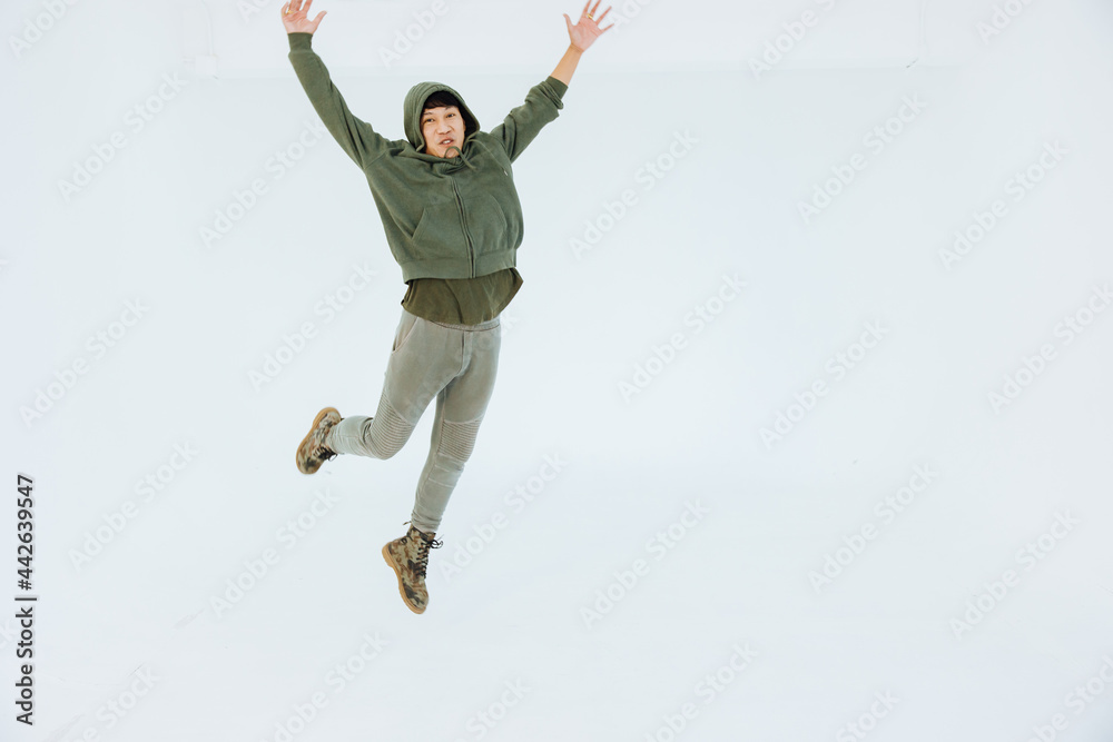 A man is performing a graceful dance in a white studio, performer masculine is a performance dancer, sportswear movement posing. A man is performing a graceful dance in a white studio, performer masculine is a performance dancer, sportswear movement posing.