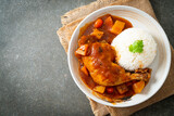 chicken stew with tomatoes, onions, carrot and potatoes on plate with rice
