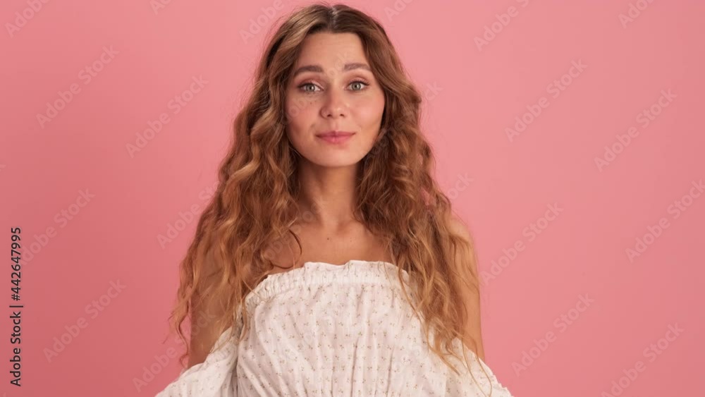 A positive woman in a lace dress saying yes and positively shaking her head in the pink studio A positive woman in a lace dress saying yes and positively shaking her head in the pink studio