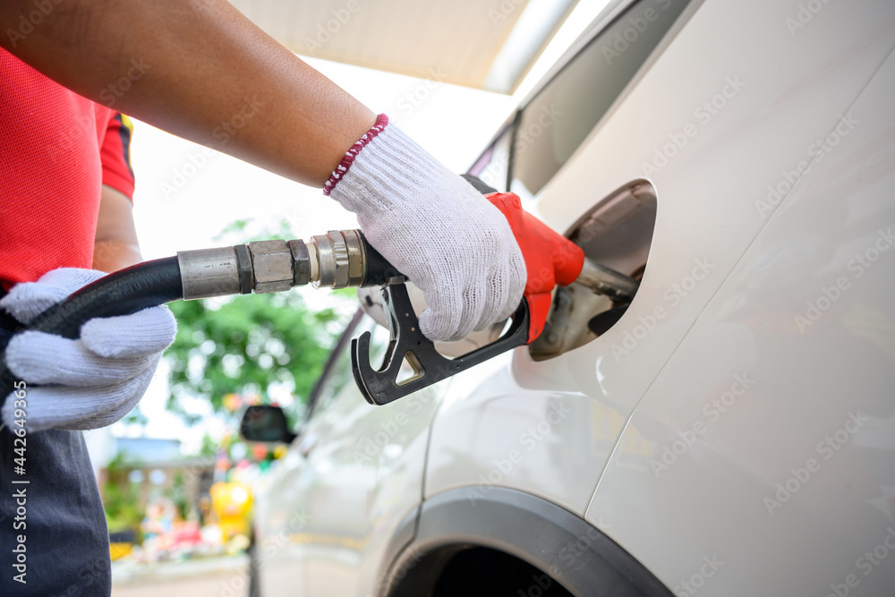 Close-up of a gas station worker working with a gasoline injector pump. to refuel Petrol pump - refueling Car refueling station. Close-up of a gas station worker working with a gasoline injector pump. to refuel Petrol pump - refueling Car refueling station.