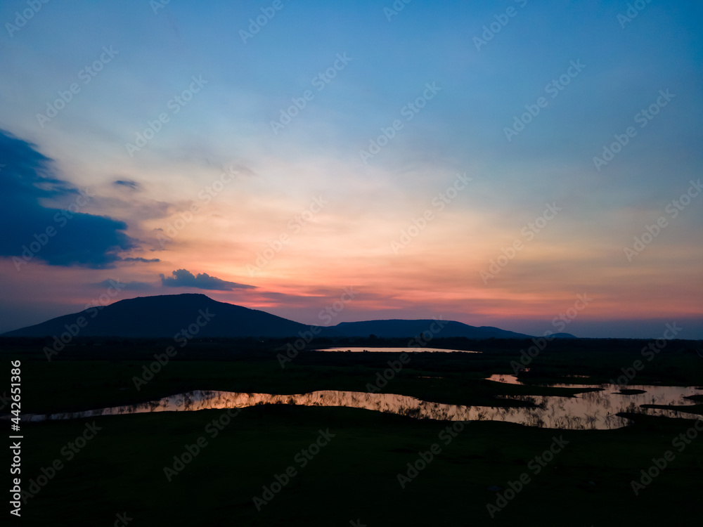 Aerial view landscape of lakeshore during dusk sky in beautiful lake with silhouette mountain.