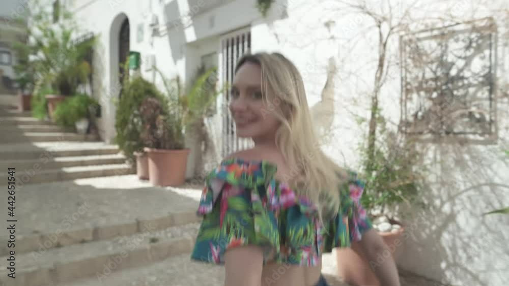 Positive smiling blond pretty woman walking through city of Altea during sunny day. 4K track shot. Positive smiling blond pretty woman walking through city of Altea during sunny day. 4K track shot.