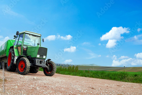 Farming  covered wagon  tractor with trailer moving on the road along vineyards on a sunny day in Rhineland Palatinate  Germany