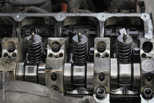 Detail of modern diesel engine repair, closeup of injectors in cylinder head with camshaft, selective focus 