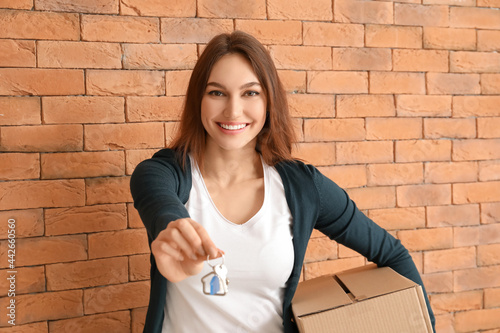 Happy young woman with key ...