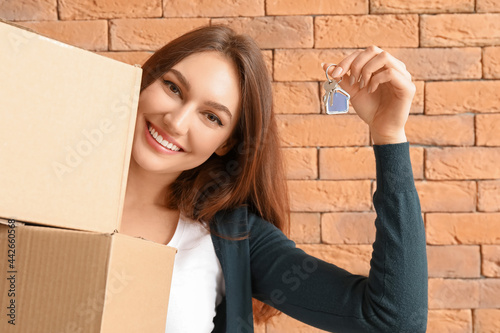 Happy young woman with key ...