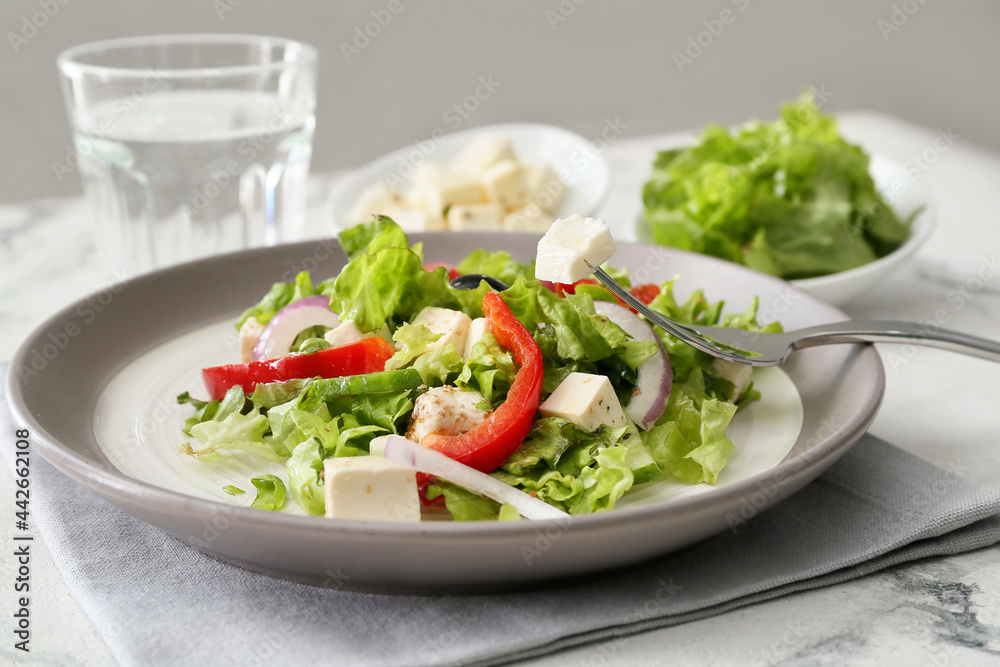 Plate with fresh Greek salad on light background Plate with fresh Greek salad on light background