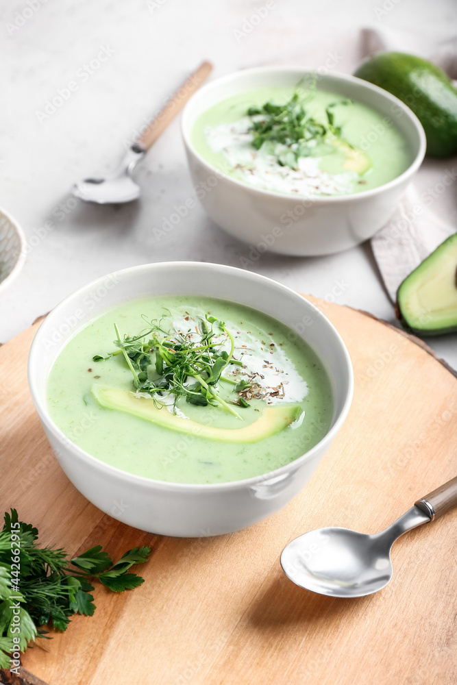 Bowls with green gazpacho and ingredients on light background Bowls with green gazpacho and ingredients on light background