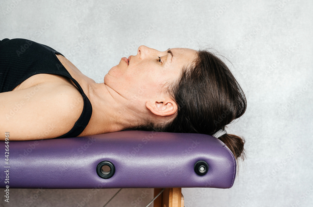 McKenzie method exercise to relieve neck pain, a woman lying on the