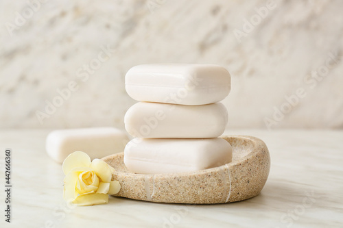 Bowl with soap bars on light background photo