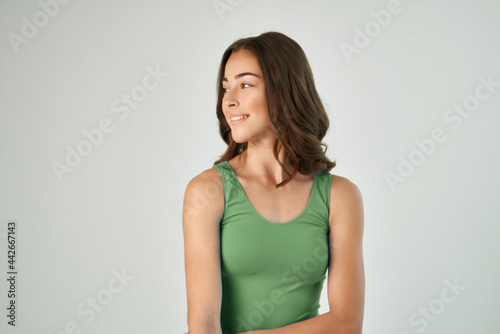 attractive brunette in green t-shirt smile fashionable hairstyle studio