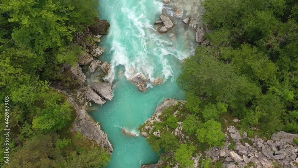 Aerial - Emerald river with huge rocks flowing through the spring forest Aerial - Emerald river with huge rocks flowing through the spring forest