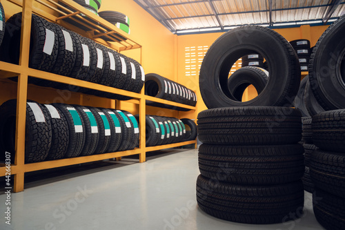 Large warehouse of car tires, rack with customer car tires in warehouse of a tire dealer