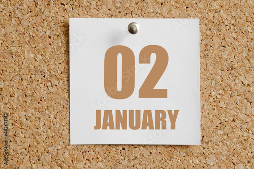 january 02. 02th day of the month, calendar date.White calendar sheet attached to brown cork board.Winter month, day of the year concept photo