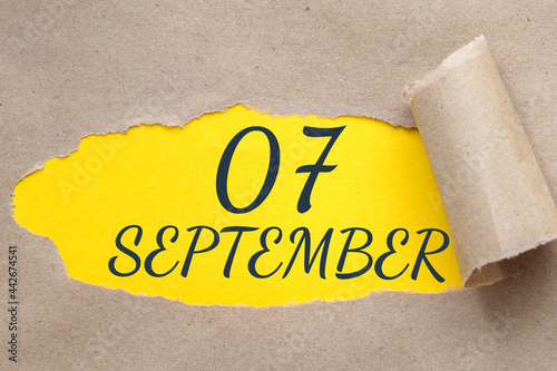 september 07. 07th day of the month, calendar date.Hole in paper with edges torn off. Yellow background is visible through ragged hole.Autumn month, day of the year concept photo