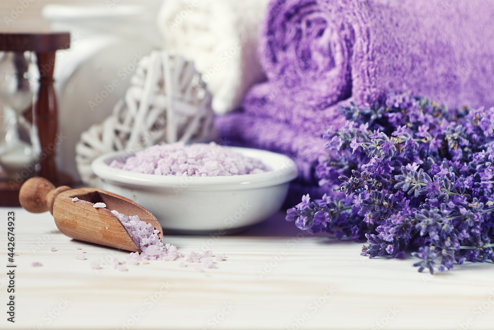 Lavender flowers, aromatic sea salt and towels. Concept for spa, beauty and health salon, cosmetics store. Close up photo on white wooden background. Lavender flowers, aromatic sea salt and towels. Concept for spa, beauty and health salon, cosmetics store. Close up photo on white wooden background.