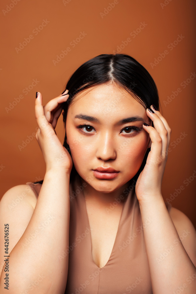 young pretty asian woman cheerful smiling posing on warm brown background, lifestyle people concept young pretty asian woman cheerful smiling posing on warm brown background, lifestyle people concept