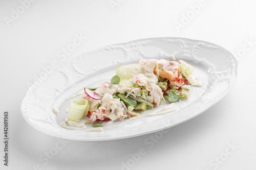 healthy salad with crab meat, radish, cucumbers and peppers isolated on white background