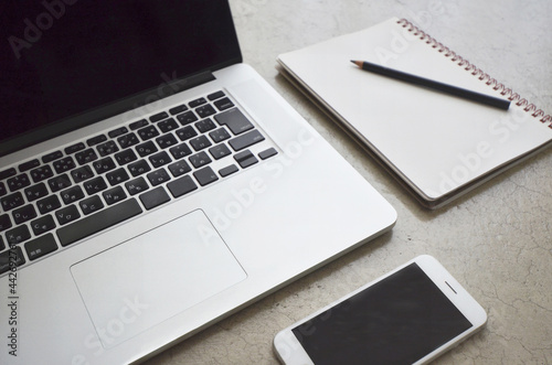 Laptop, smartphone,notebook,pencil on modern concrete table