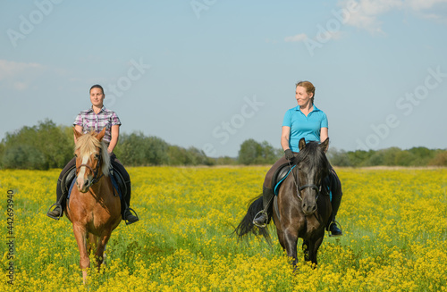 Two female horse riders are in outdoors.