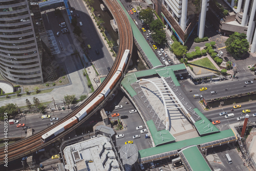 Photography Public skywalk located above an intersection at Bangkok downtown, Thailand with a Metro on the track above the street