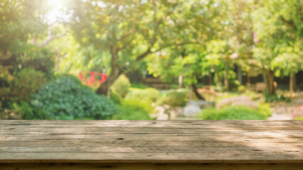 Empty wood table top with abstract blur park garden pond background
