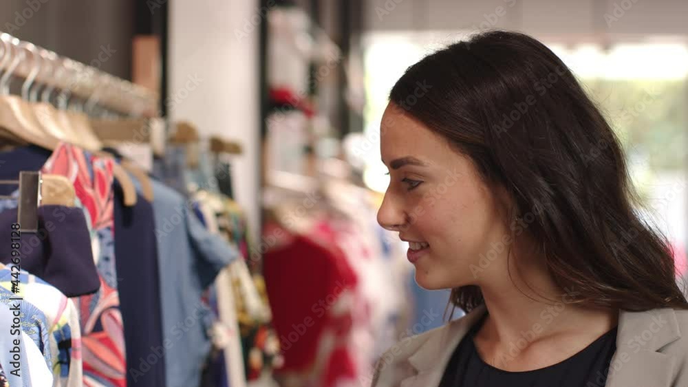 Young woman shopping for clothes in fashion boutique Young woman shopping for clothes in fashion boutique