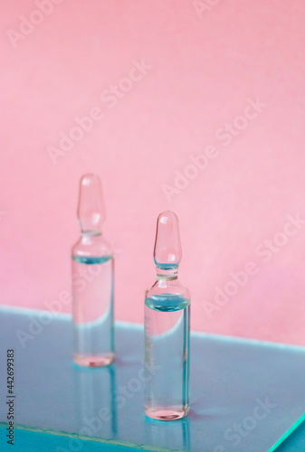 Ampoules for medical and cosmetic products on a pink background. Substance solution for injection
