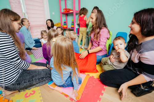 Lovely preschool girl at a meeting of mothers with kids