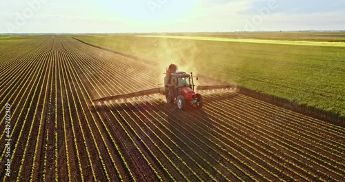 Farmer on tractor spraying soybean field photo