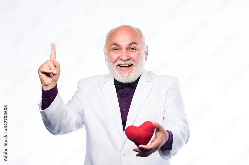 Heart and healthcare. Diagnostics and treatment. Preventing heart attack. Senior bald head bearded man holding red toy heart in hands. Health care. Healthy life. Cheerful man with valentines heart Heart and healthcare. Diagnostics and treatment. Preventing heart attack. Senior bald head bearded man holding red toy heart in hands. Health care. Healthy life. Cheerful man with valentines heart