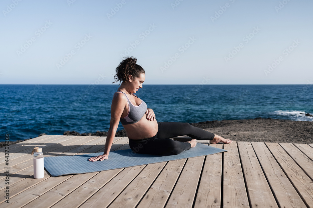 Young pregnant woman doing yoga workout routine outdoor - Focus on face