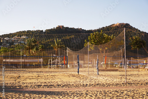 Fototapeta Naklejka Na Ścianę i Meble -  Volleyball court on the beach in Alanya, Turkey. Hot weather, palms and mountains on the background