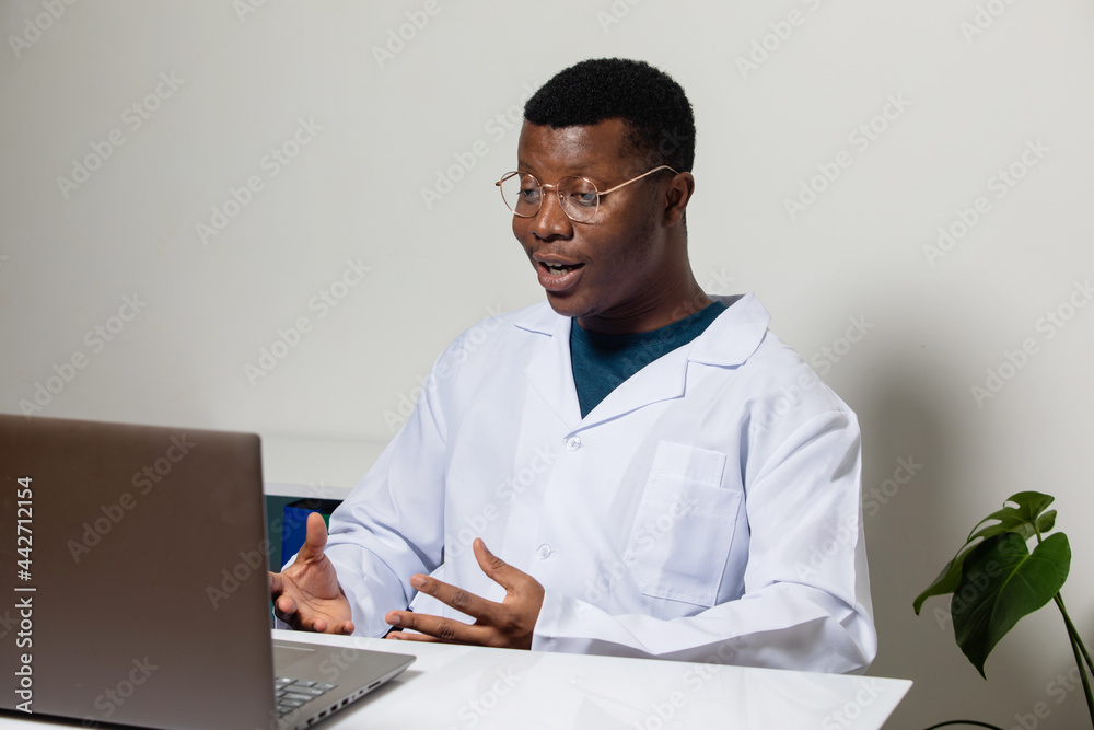 Cheerful doctor sitting in front of laptop during videocall Cheerful doctor sitting in front of laptop during videocall