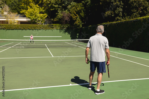 Senior caucasian couple playing tennis together on court © wavebreak3