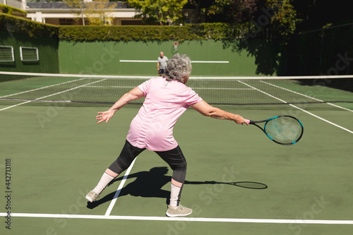 Senior caucasian couple playing tennis together on court