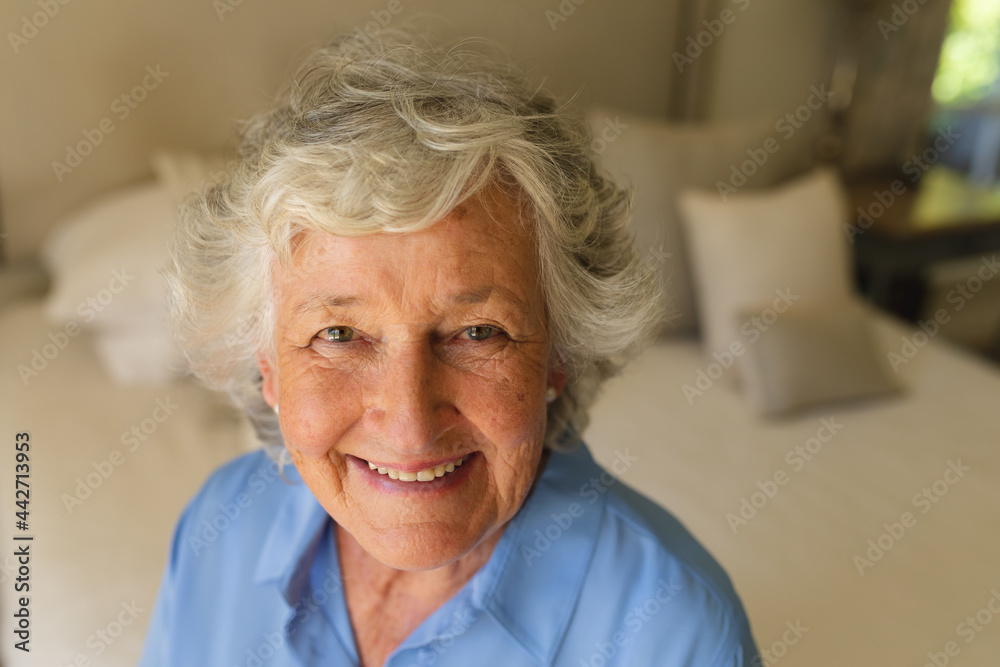 Portrait of senior caucasian woman sitting on bed and smiling in bedroom Portrait of senior caucasian woman sitting on bed and smiling in bedroom