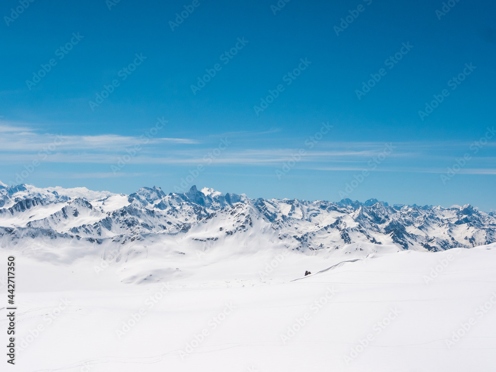 Panoramic view of the Caucasus Mountains from Cheget, height 3050 meters, Kabardino-Balkaria, Russia. Photo of snow-capped peaks against the blue sky.