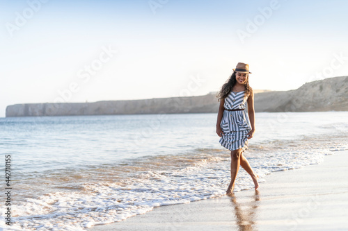 Portrait of a beautiful young woman on the beach by sunset