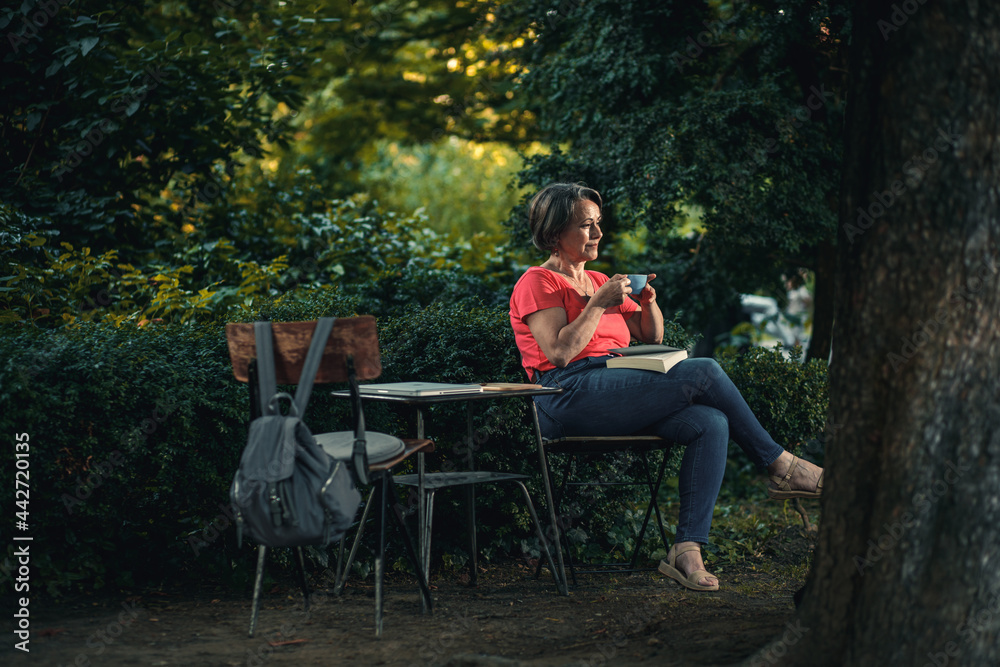 Senior woman reading book in outdoor coffee shop. Senior woman reading book in outdoor coffee shop.