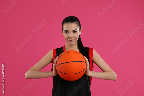 Basketball player with ball on pink background