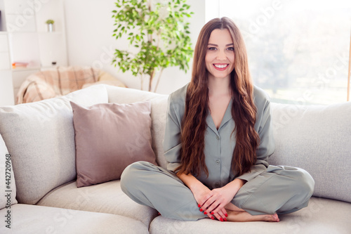 Full length photo of young cheerful pretty girl happy positive smile sit couch wear pajamas nightwear home