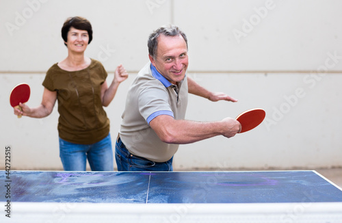 mature man and woman playing table tennis