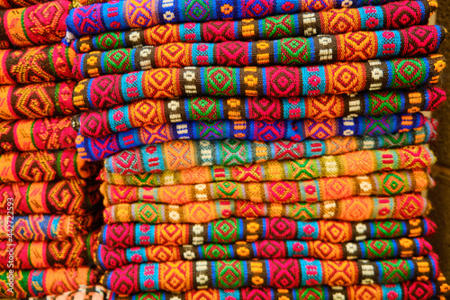 Folded colorful middle eastern carpets at bazaar. Traditional oriental fabric pieces