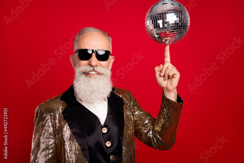 Photo of senior man happy positive smile spin disco ball finger concert showman isolated over red color background