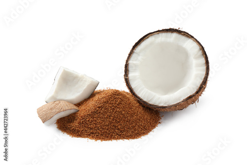 Ripe coconut and pile of brown sugar on white background