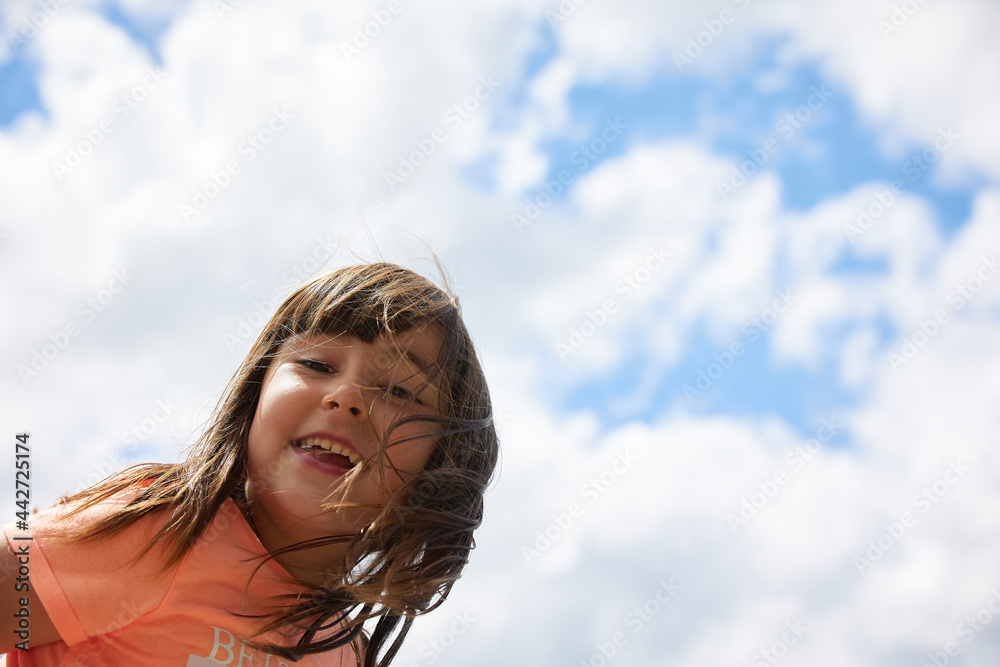 Latin funny girl looking at camera with cloudy sky in the background with a large copy space in the background Latin funny girl looking at camera with cloudy sky in the background with a large copy space in the background